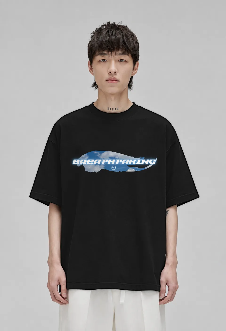 Model wearing the black Breathtaking oversized t-shirt with the sky-blue cloud Breathtaking banner, front view