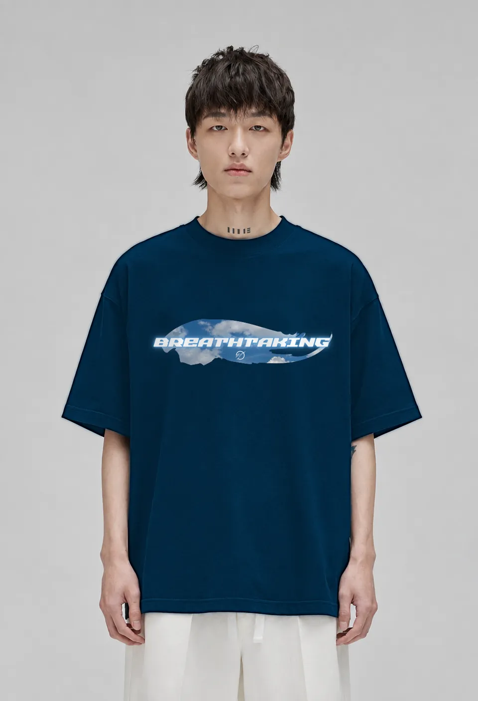 Model wearing the navy blue Breathtaking oversized t-shirt with the sky-blue cloud Breathtaking banner, front view