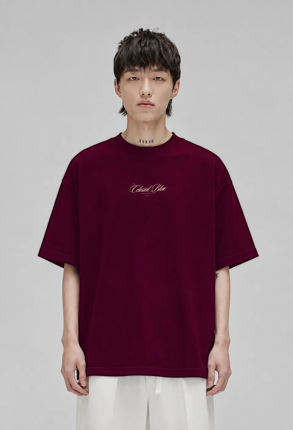Model wearing the burgundy Classic oversized t-shirt with the cream Celesial Blue script, front view