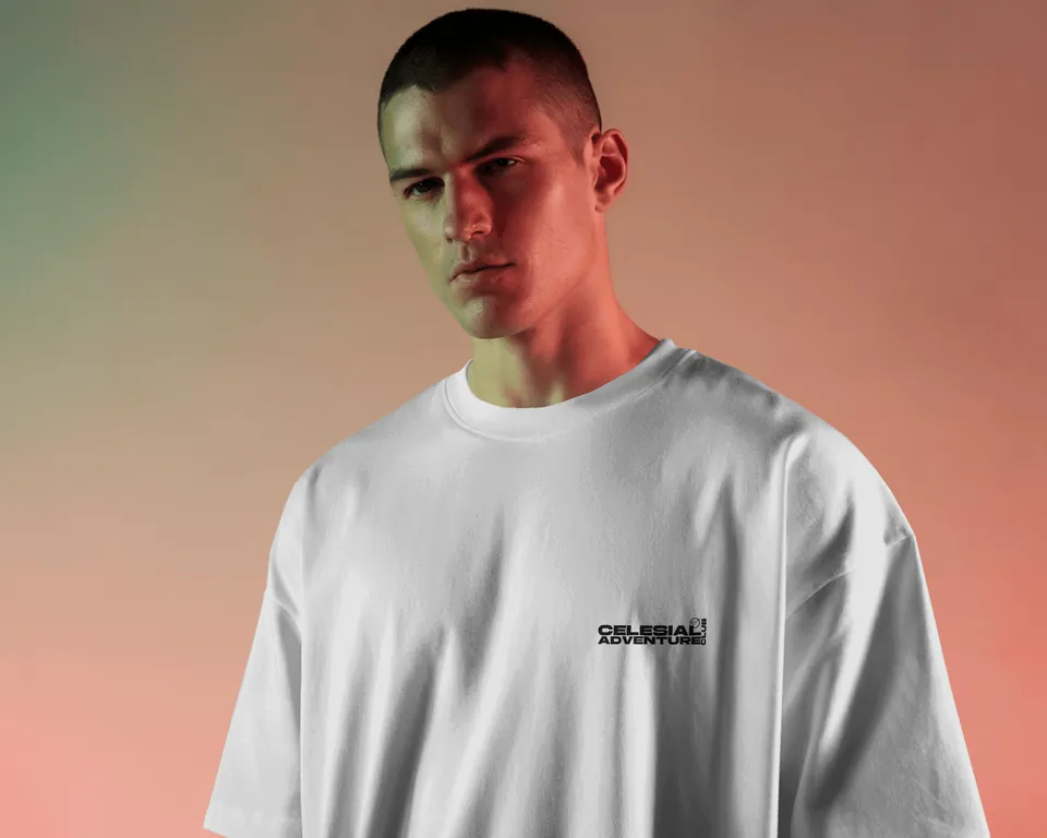 Model wearing the Saint White Consciousness oversized t-shirt against a peach wall