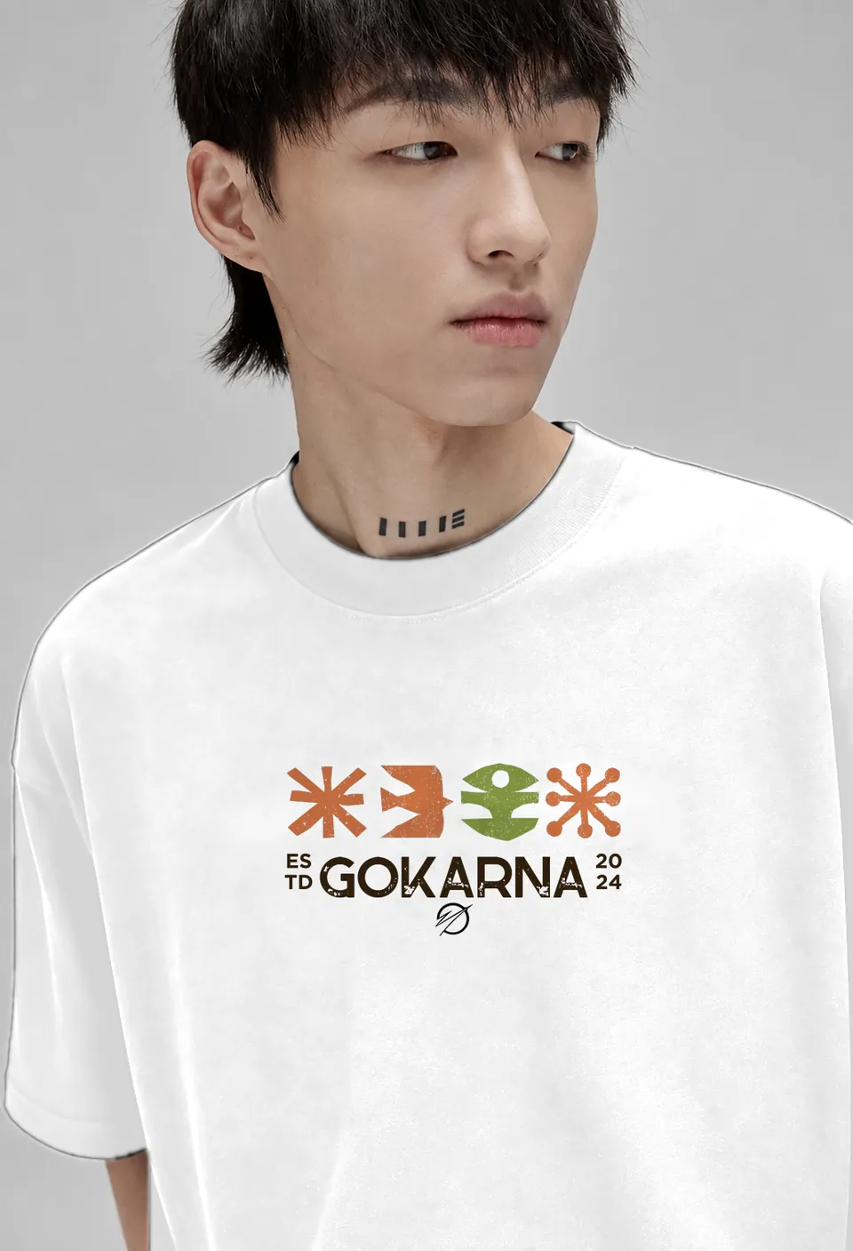 Close-up of the Gokarna Estd 2024 print on a white oversized t-shirt
