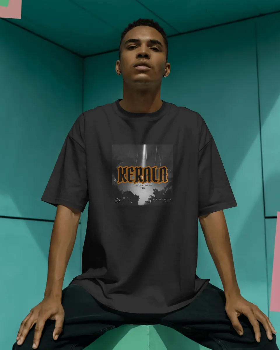 Model sitting in the black Kerala oversized t-shirt in a teal room