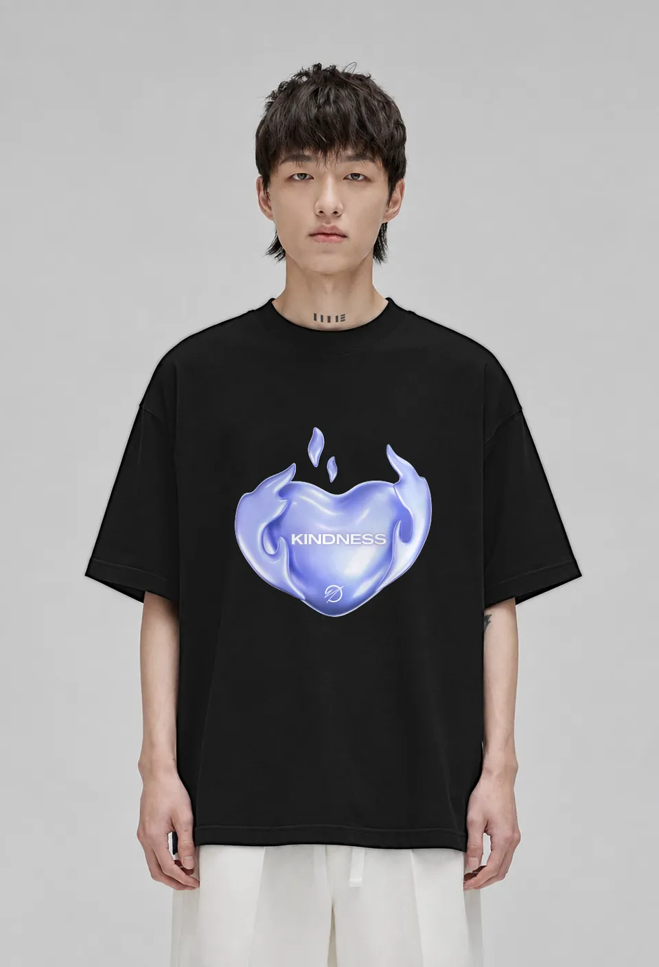 Model wearing the black Kindness oversized t-shirt with the lavender chrome Kindness heart, front view
