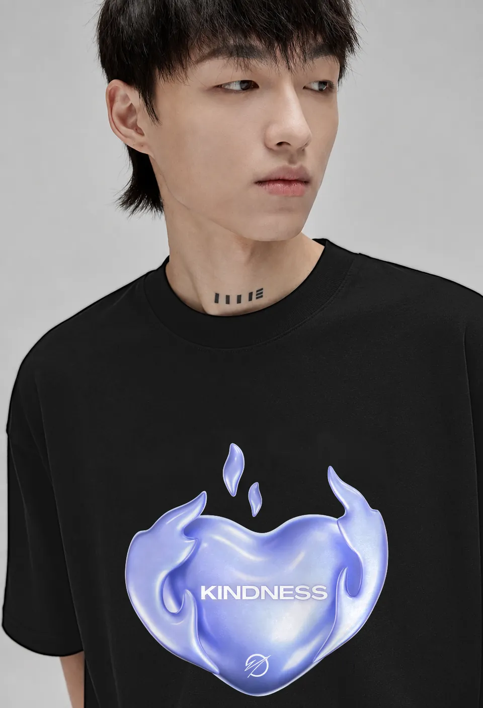 Close-up of the lavender chrome Kindness heart on a black oversized t-shirt