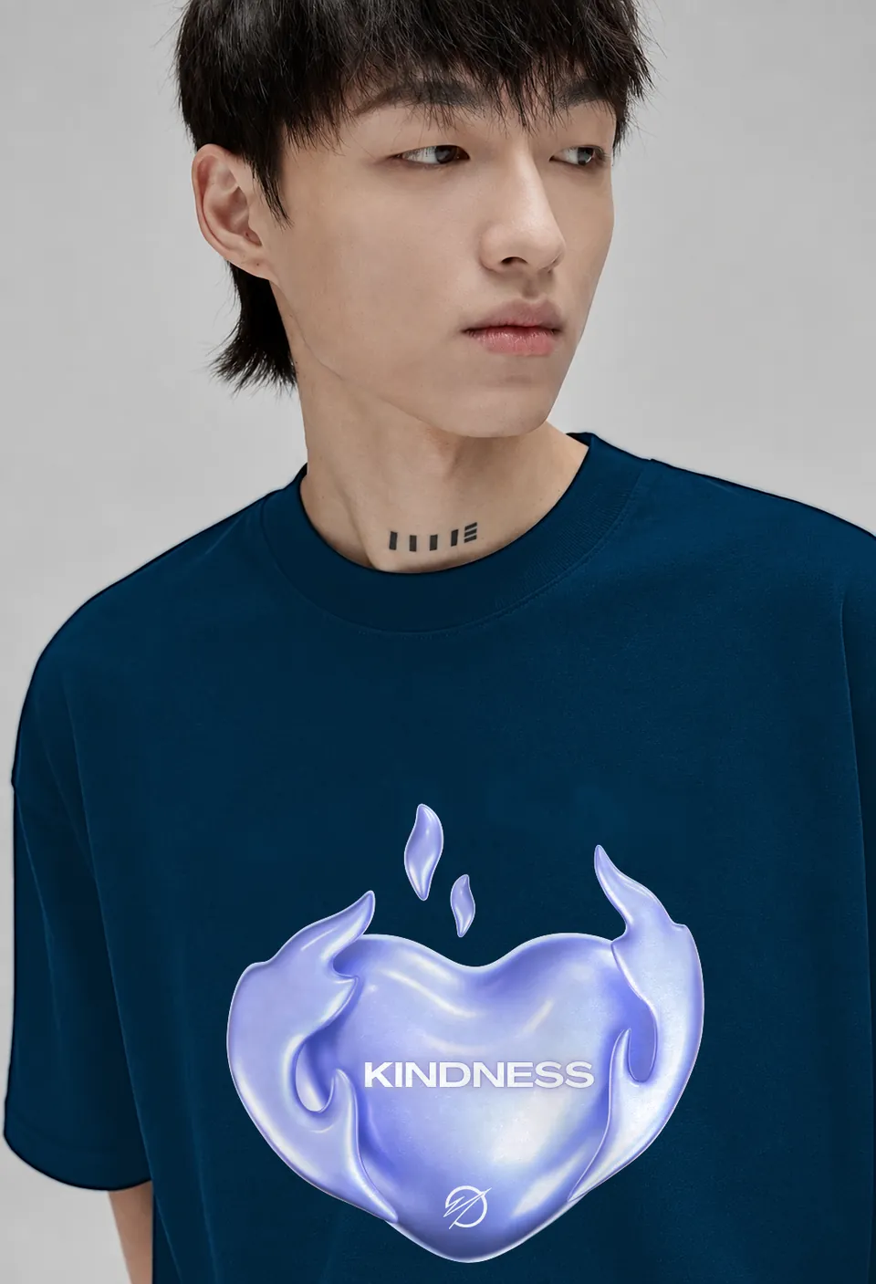 Close-up of the lavender chrome Kindness heart on a navy blue oversized t-shirt