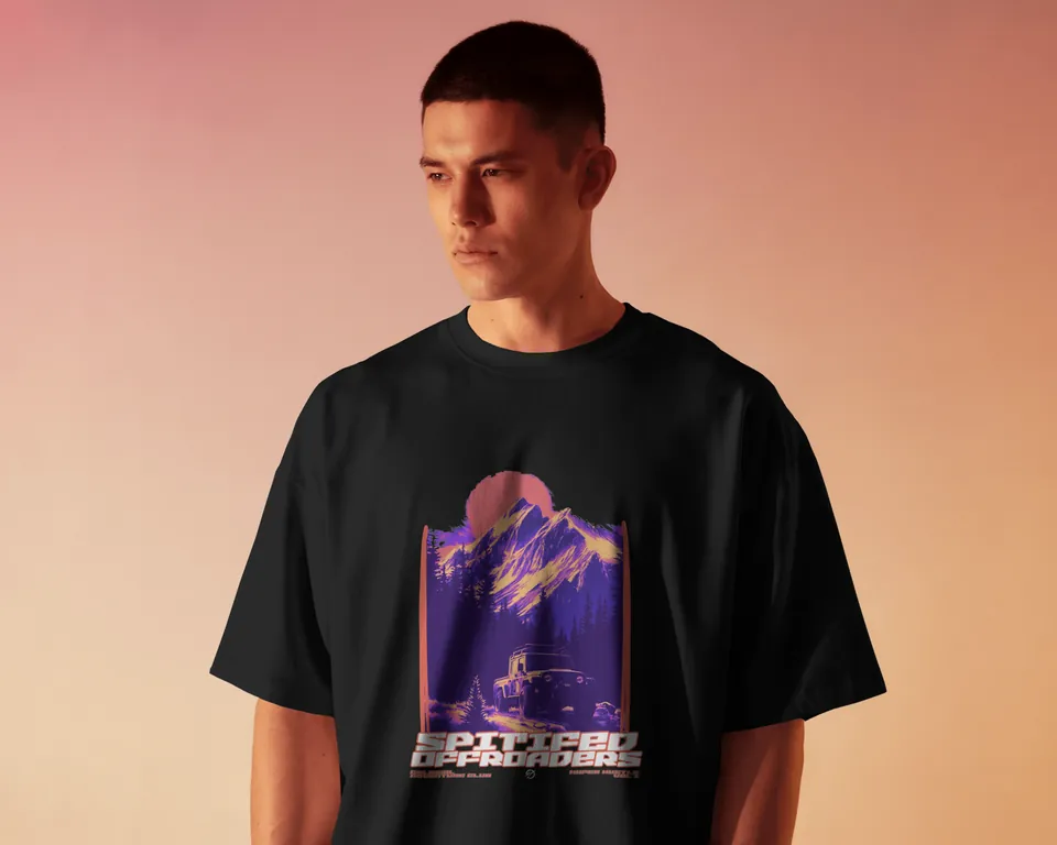 Model wearing the black Spitified oversized t-shirt against a peach wall